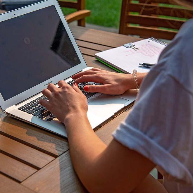 Closeup of student’s hands on laptop paying their bill